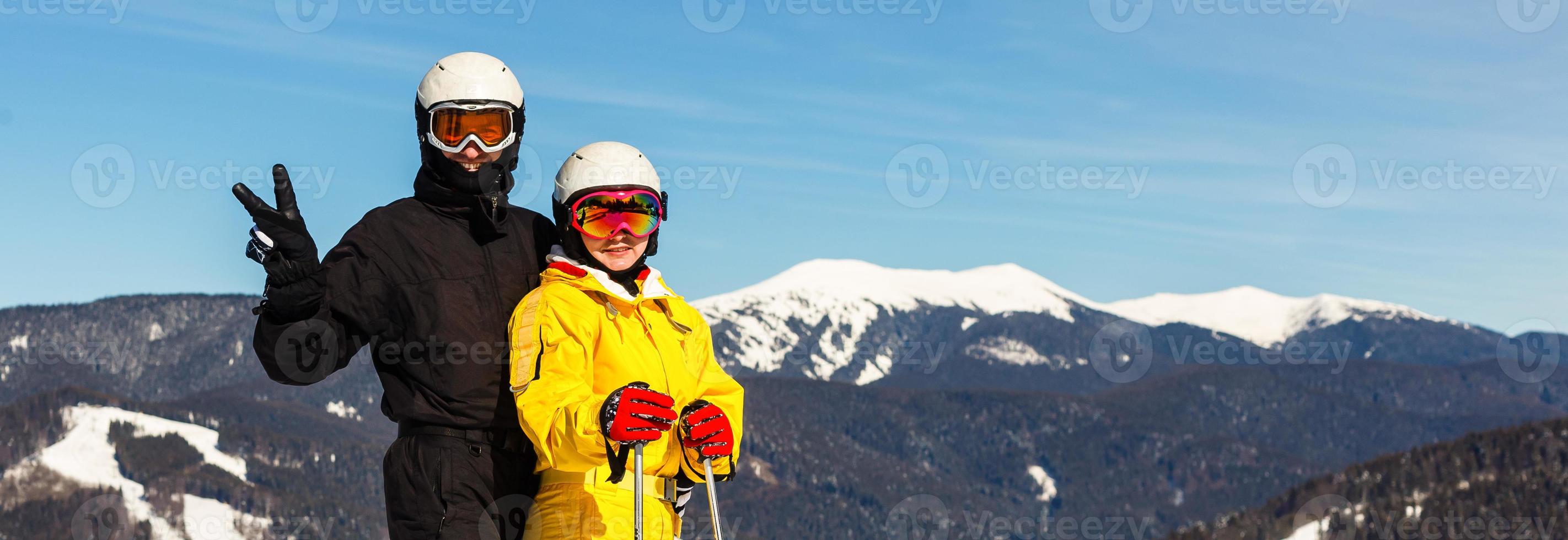 feliz hombre y mujer esquiadores contra el fondo de montañas nevadas foto
