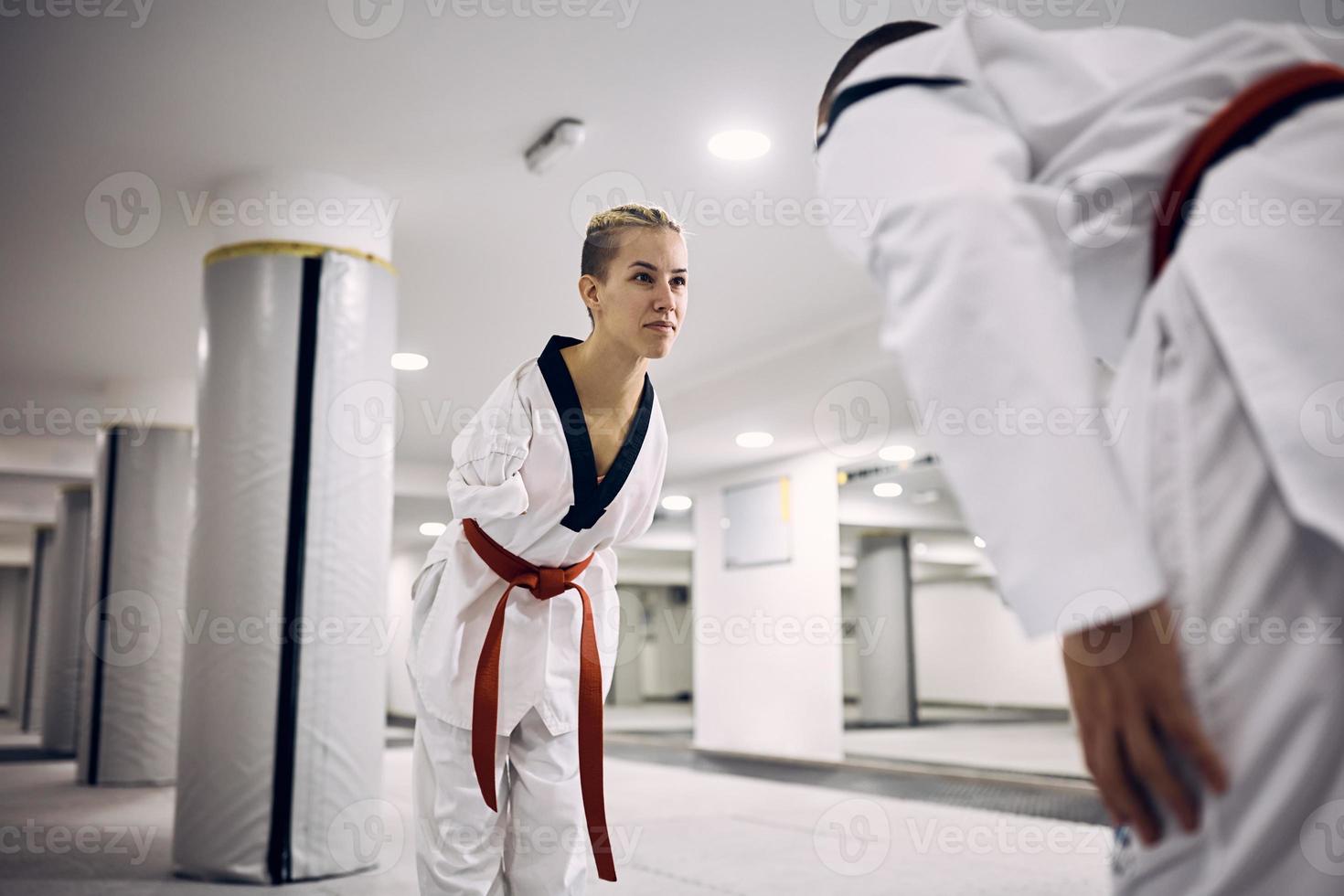 Martial artist with disability greeting her sparing partner before the fight during taekwondo training in health club. photo