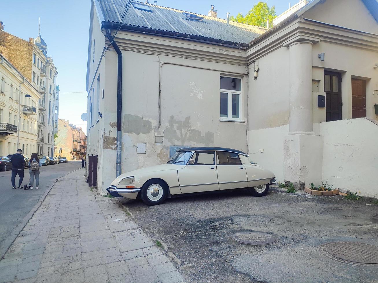 Vilnius, Lithuania, 2022 - Building corner exhibition of old beige Citroen car unexpected finding in Vilnius old town photo