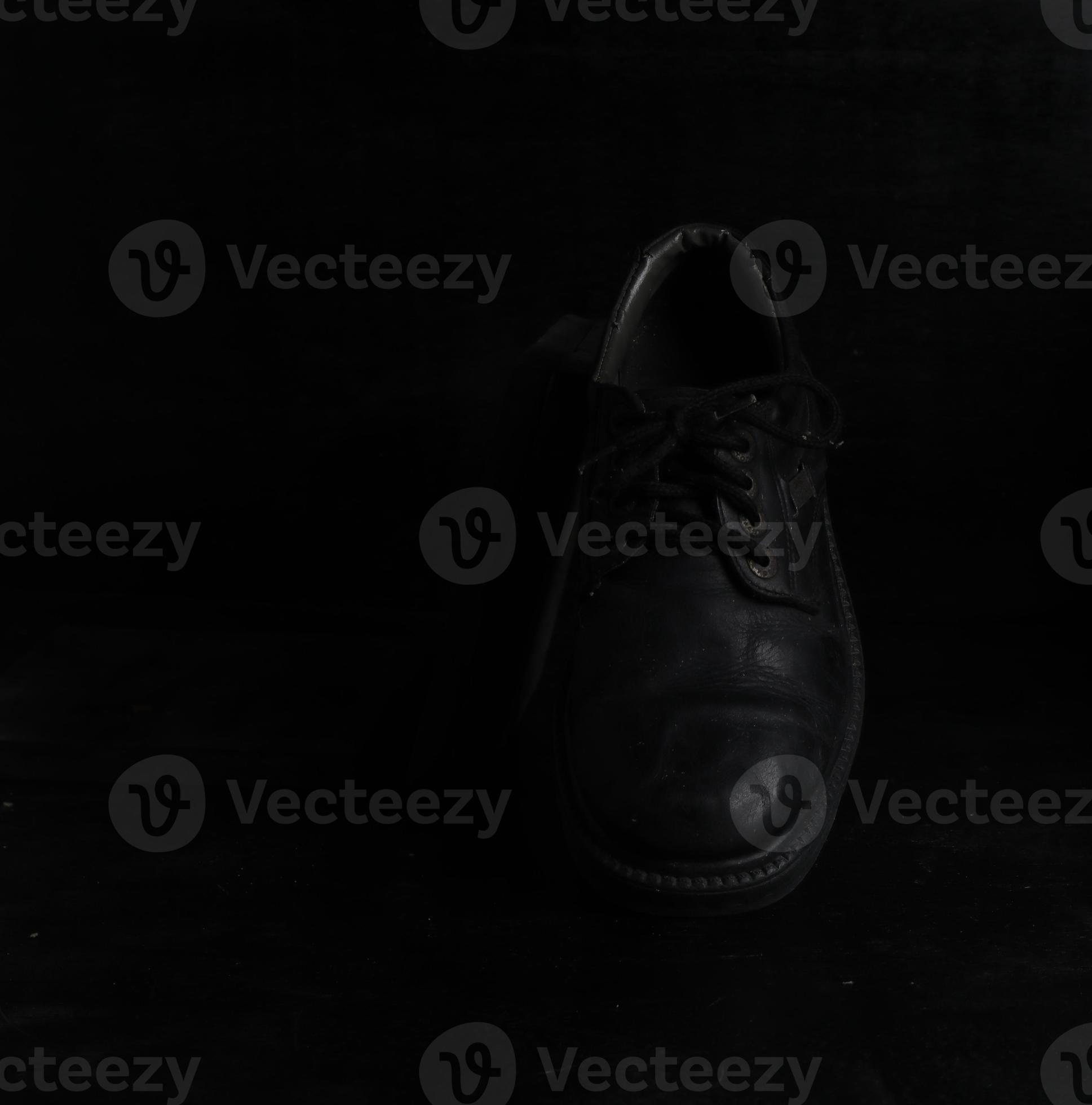 Pair of black male classic shoes on black background. Dusty shoes