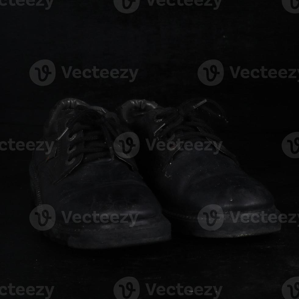 Pair of black male classic shoes on black background. Dusty shoes photo