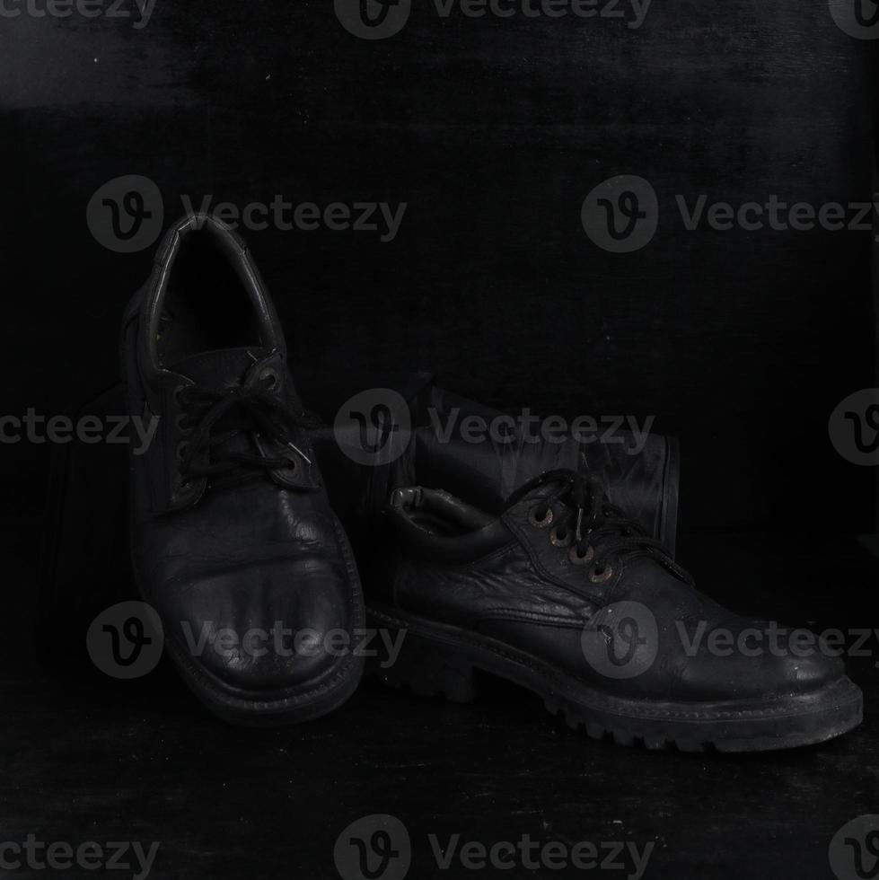 Pair of black male classic shoes on black background. Dusty shoes photo