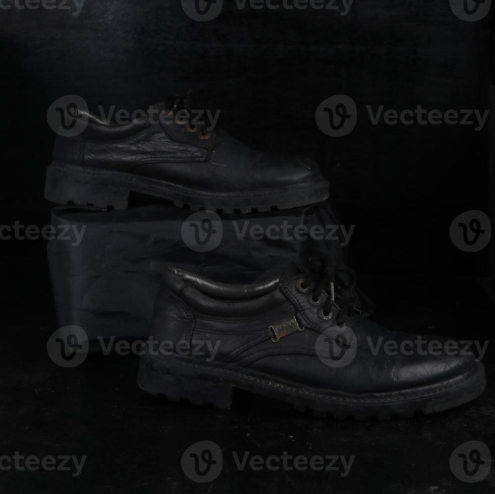 Pair of black male classic shoes on black background. Dusty shoes photo