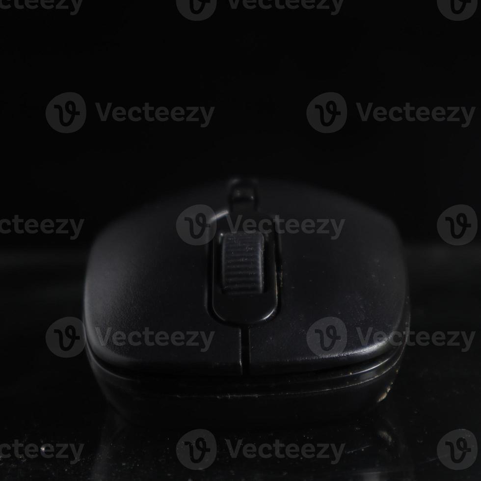 Black computer mouse on black background photo
