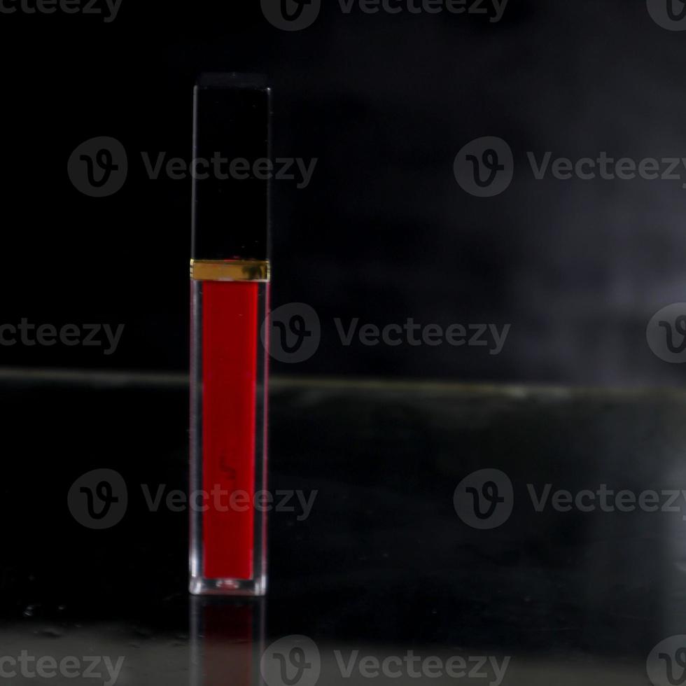 Red lipstick isolated on black background photo