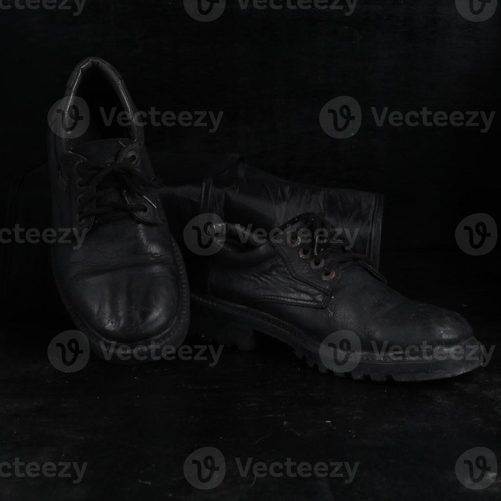 Pair of black male classic shoes on black background. Dusty shoes photo