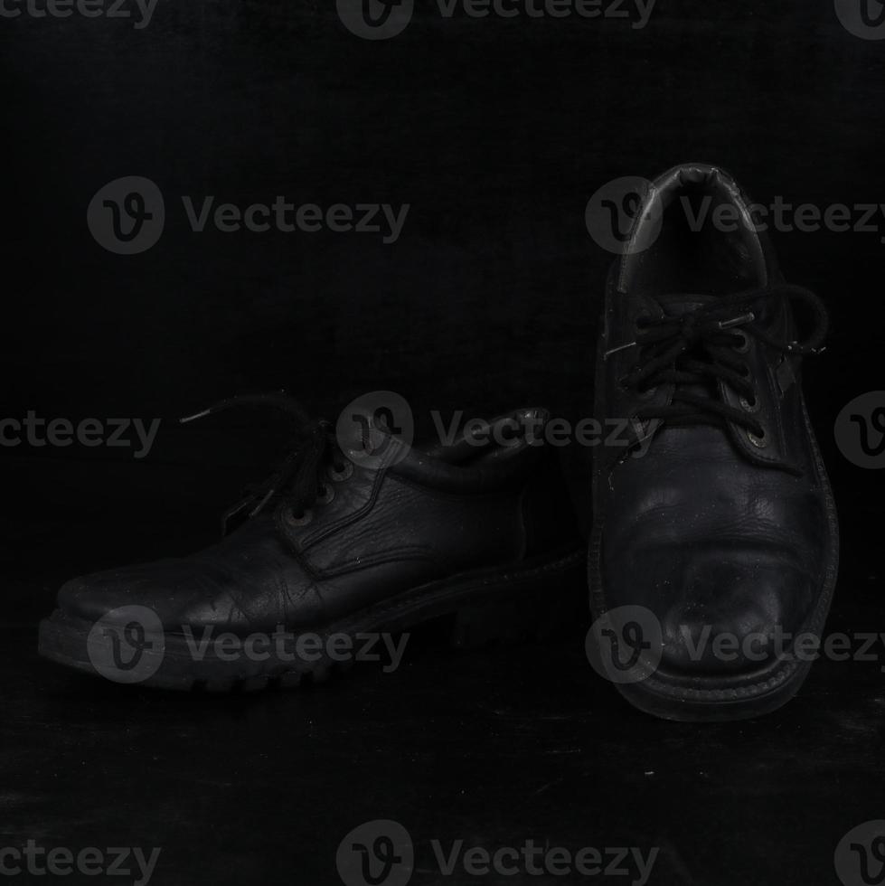 Pair of black male classic shoes on black background. Dusty shoes photo