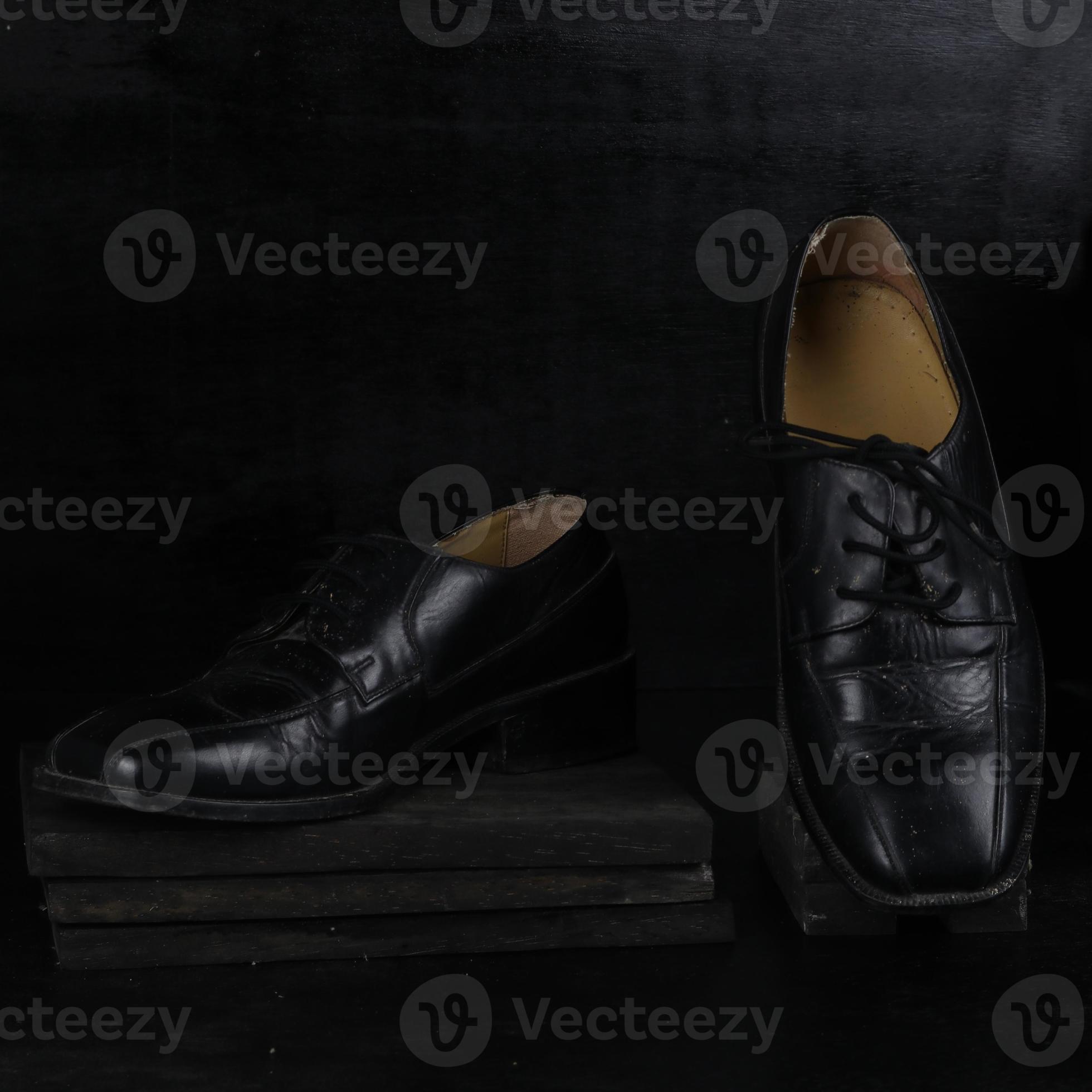 Pair of black male classic shoes on black background. Dusty shoes