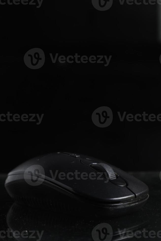 Black computer mouse on black background photo