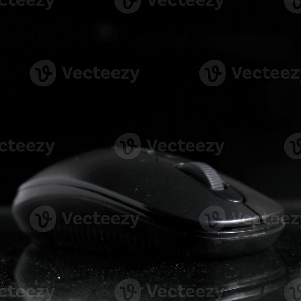 Black computer mouse on black background photo