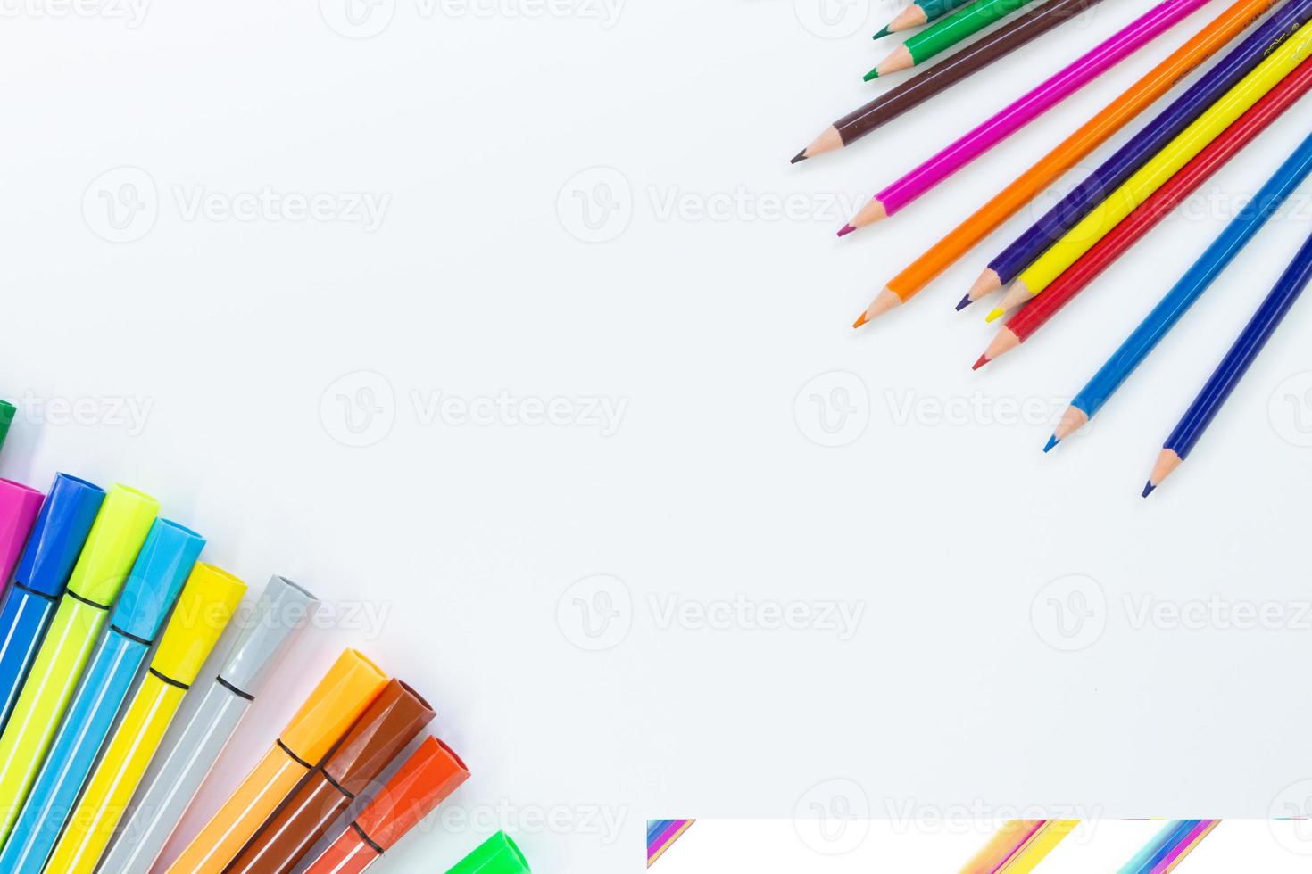 Back to school. From the corners there are colored pencils, on the other hand markers or felt tip pens on white background with place for text. Learning concept. Copy space photo