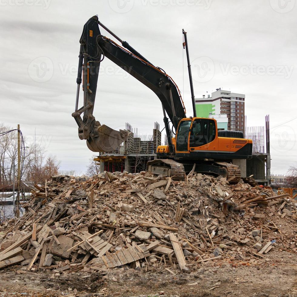 Demolition of an old building by modern excavator photo