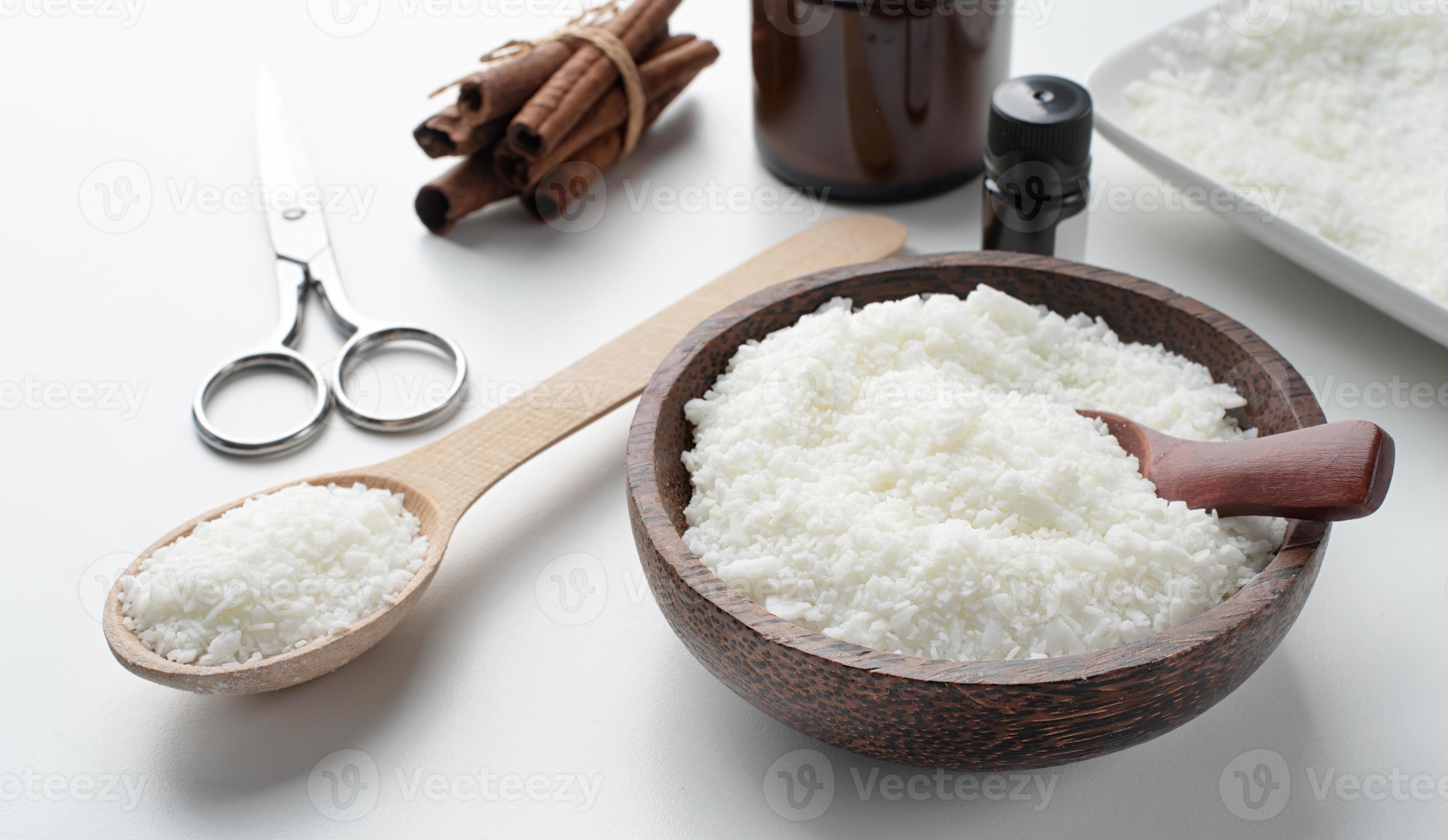 Wooden spoon on heap of soy wax flakes, top view. Homemade candle material  Stock Photo