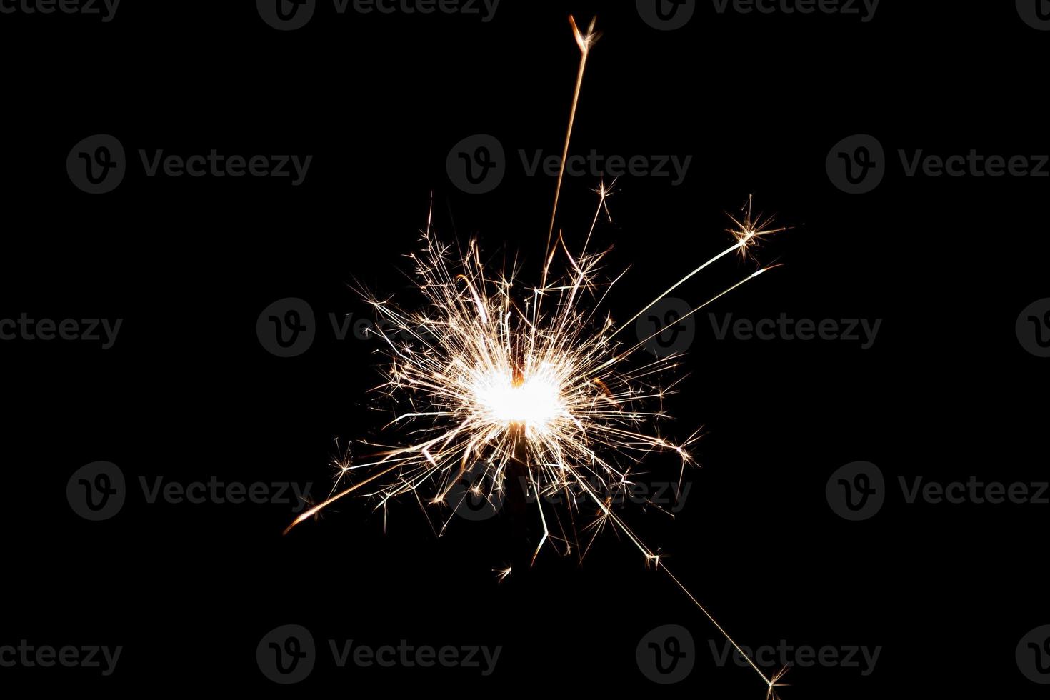 Burning sparkler isolated on black background. Fireworks theme. Light effect and texture. photo