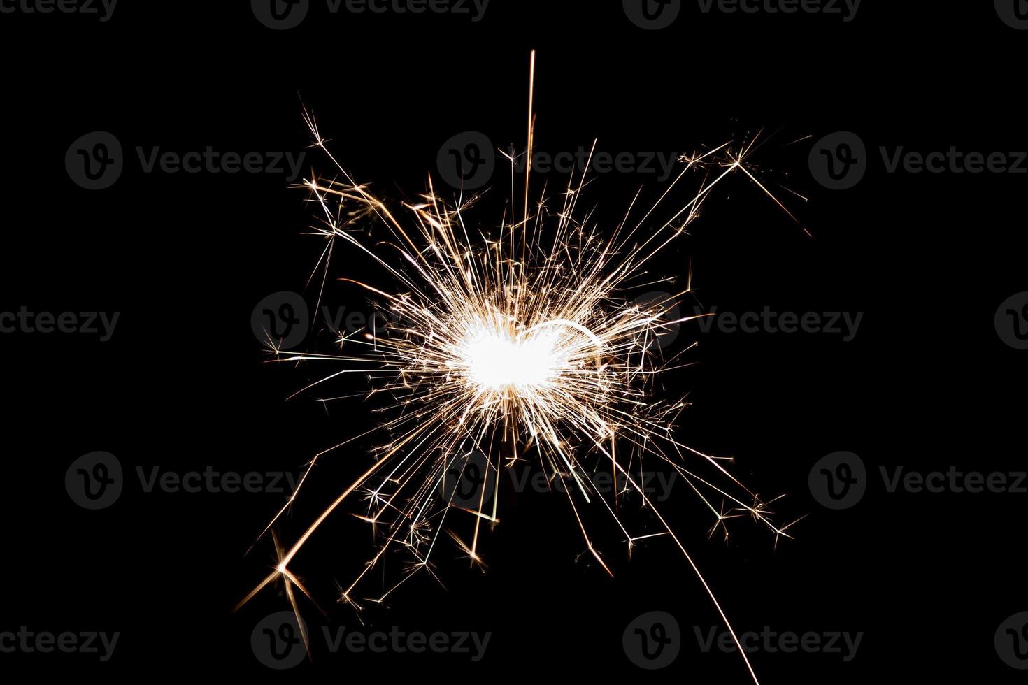 Burning sparkler isolated on black background. Fireworks theme. Light effect and texture. photo