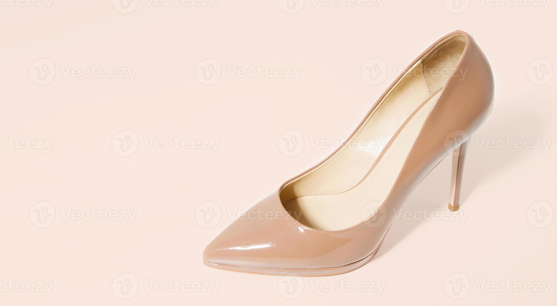 Zapato de charol de beige de primer aislado sobre fondo rosa. zapato tipo stilettos.