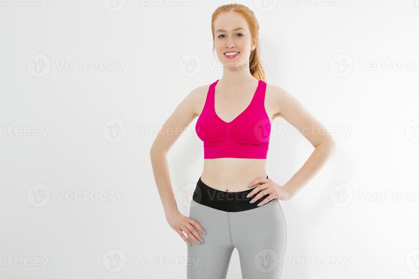 Young red haired girl in sport wear clothes isolated on white background. Slim body figure and healthy lifestyle. Fitness and sports concept. Banner photo