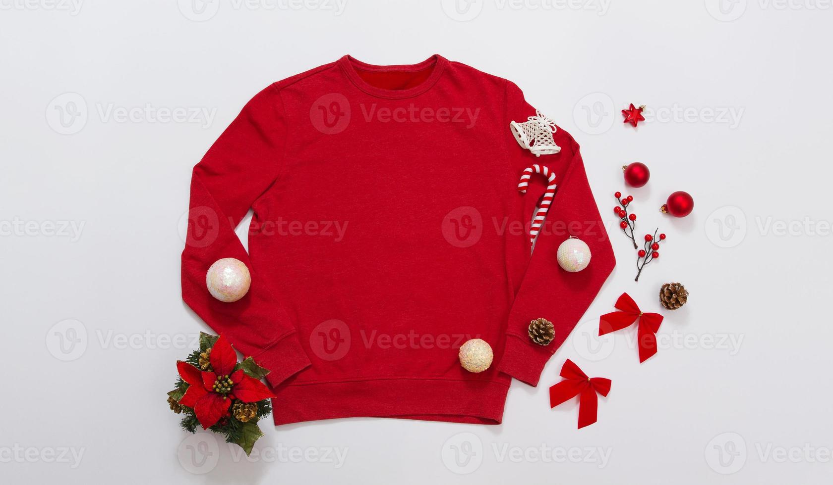 Close up banner red blank template sweatshirt with copy space and Christmas Holiday concept. Top view mockup hoodie and red holidays decorations on white background. Happy New Year accessories. Xmas photo