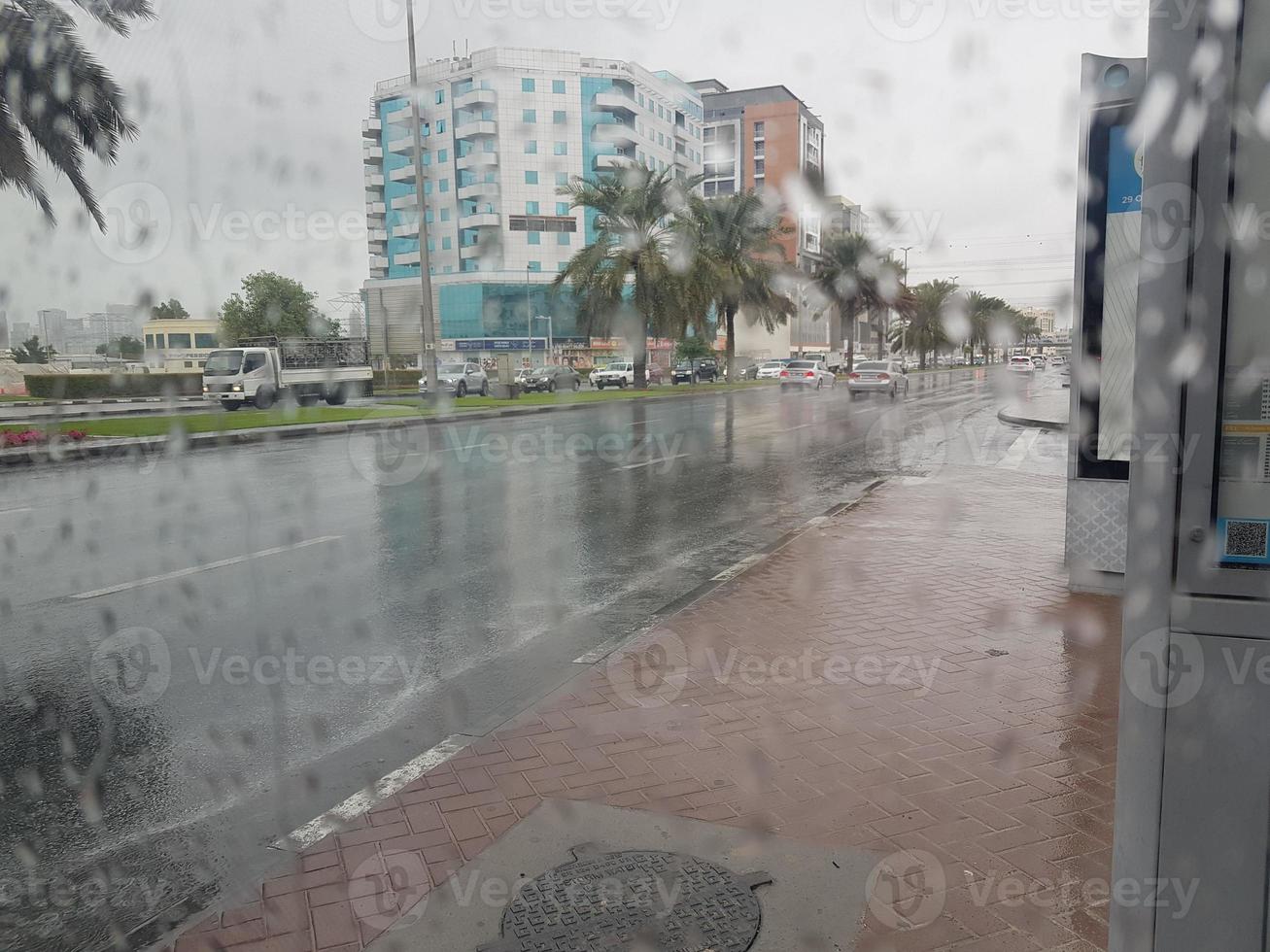 lluvia en los emiratos árabes unidos hermosa vista al lado de la carretera y sala de estar repartidor disfrutando en la lluvia bebé jugando silla hierba en la lluvia, el tráfico continúa en la carretera en un día lluvioso foto