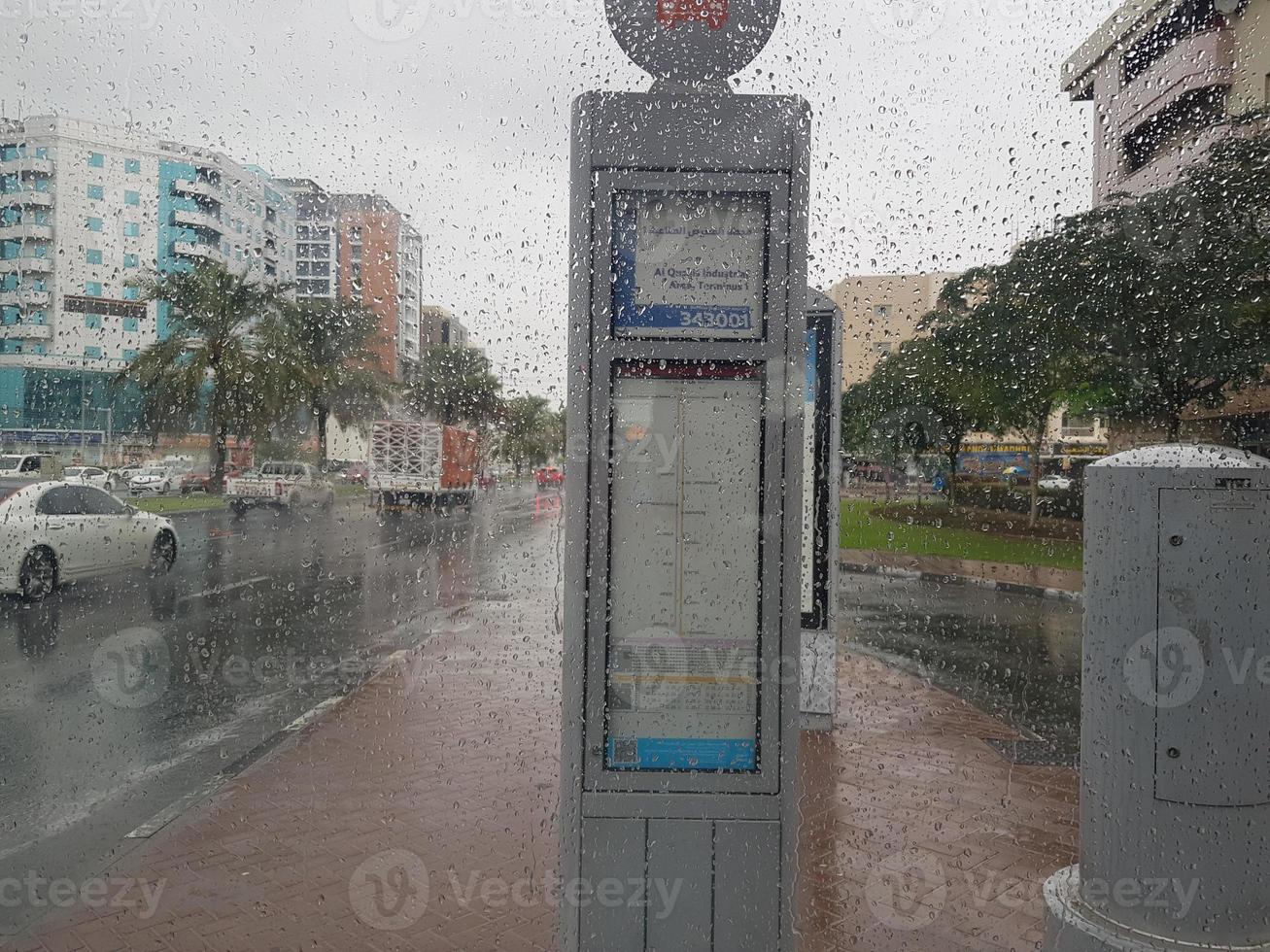 lluvia en los emiratos árabes unidos hermosa vista al lado de la carretera y sala de estar repartidor disfrutando en la lluvia bebé jugando silla hierba en la lluvia, el tráfico continúa en la carretera en un día lluvioso foto