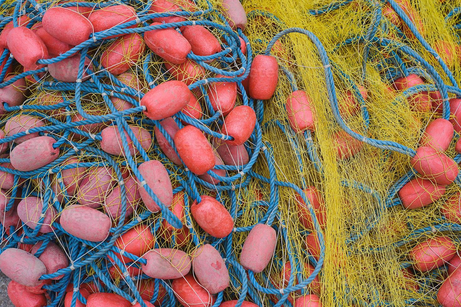 Fishing net with ropes and floats is drying on the pier, close-up, selective focus photo
