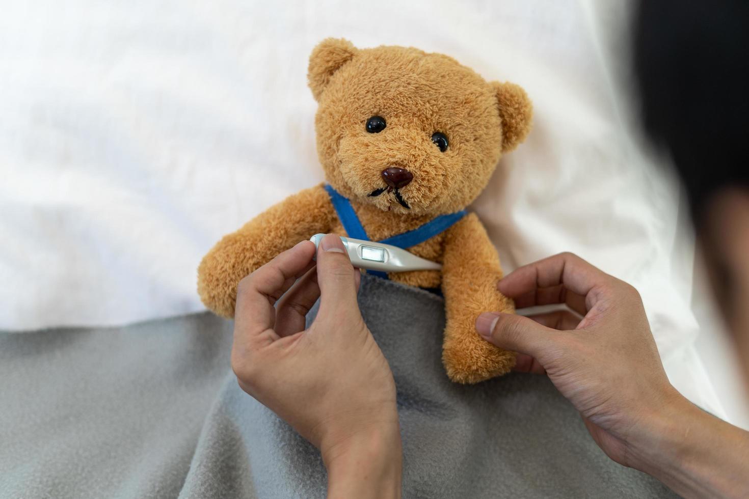 Teddy bear and bandage with thermometer. sick and injury concept photo