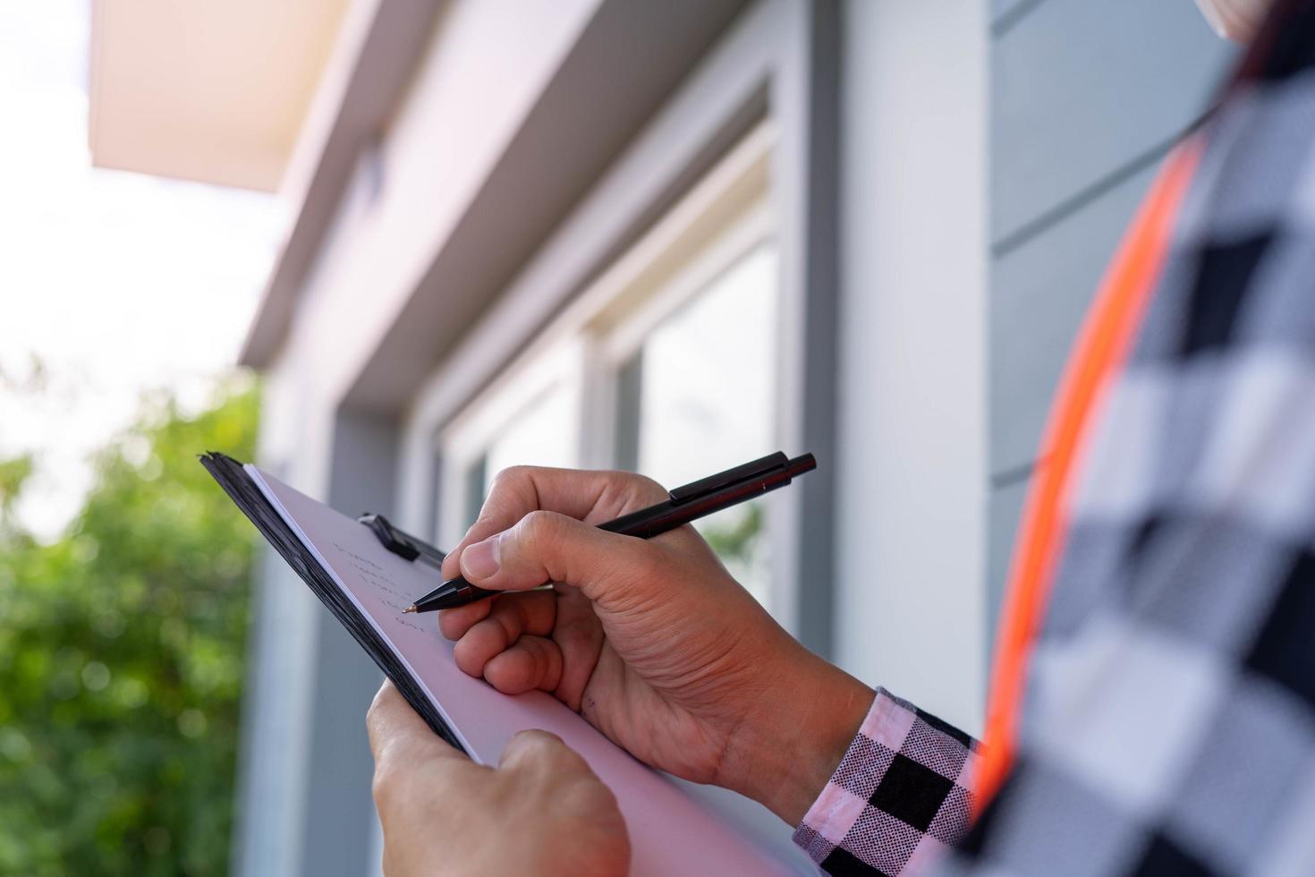 inspector or engineer is inspecting construction and quality assurance new house using a checklist. Engineers or architects or contactor work to build the house before handing it over to the homeowner photo