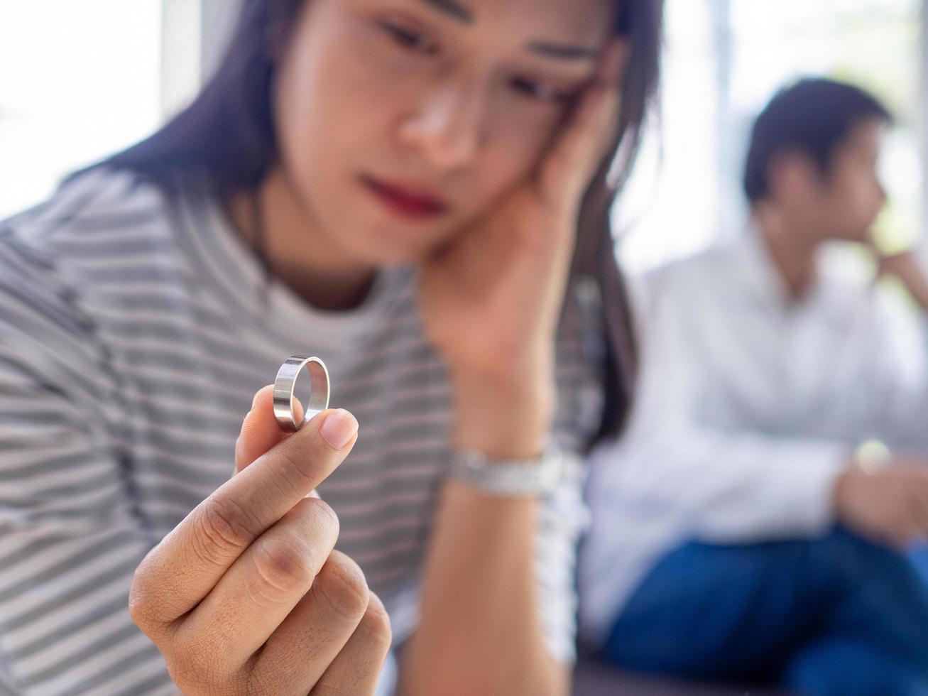 Asian women feel sad and irritated by the behavior of her husband. After quarreling until the wedding ring is removed in the hand. Causing pain in the heart photo