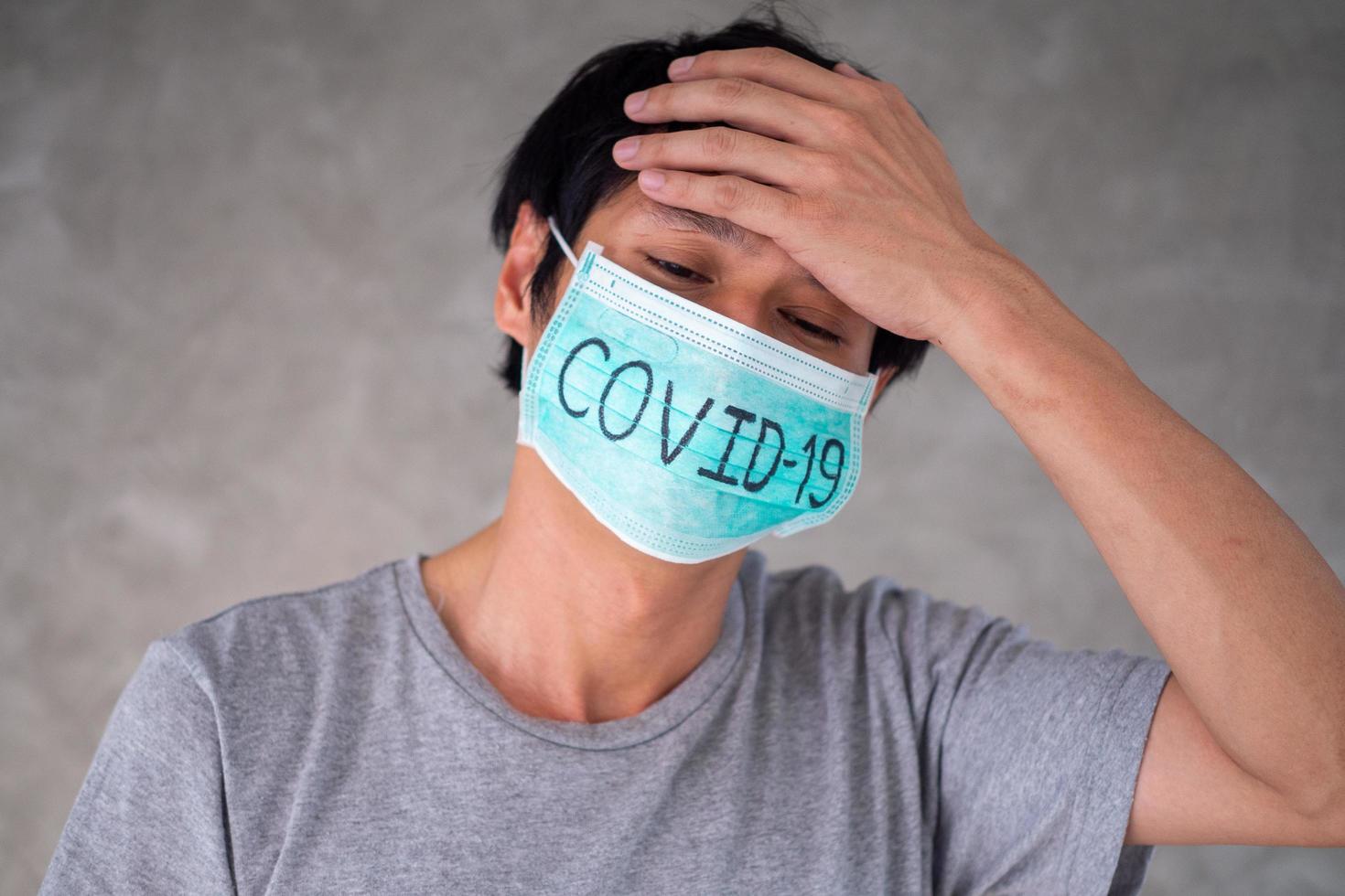 el hombre asiático se preocupa y teme usar máscara, escribe covid-19 la situación de la infección por el virus 2019-ncov en wuhan se está extendiendo por todo el mundo. plaga mortal del mundo concepto enmascarado para proteger foto