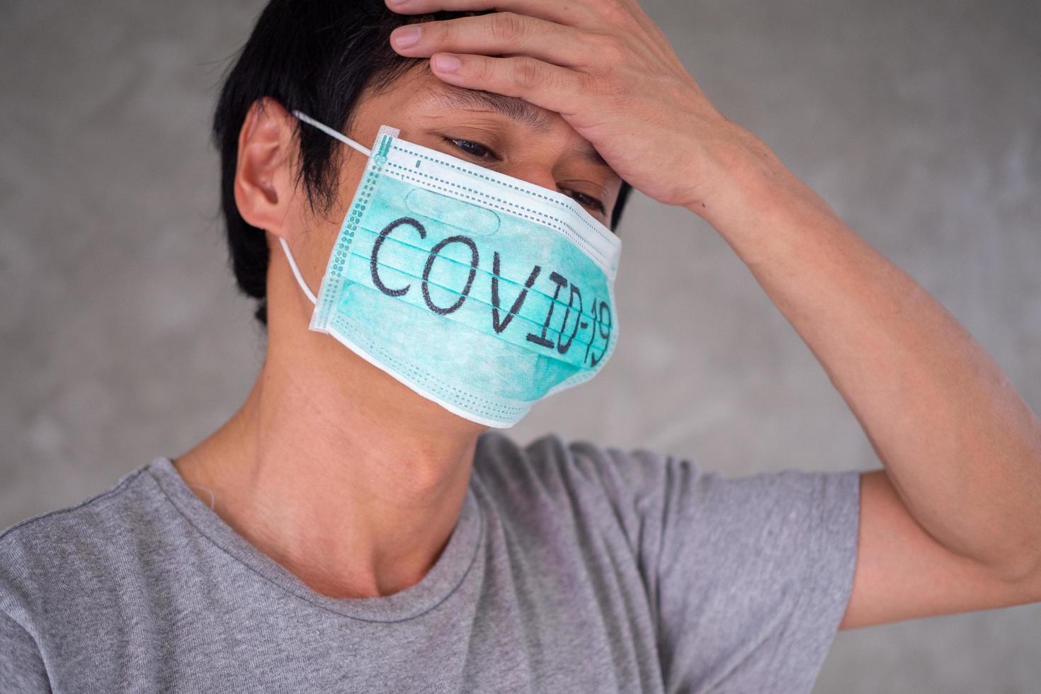 Asian man Worry and Fears Wearing Mask, writes Covid-19 The situation of the 2019-nCoV virus infection in Wuhan is spreading all over the world. Deadly plague of the world Masked concept to protect photo