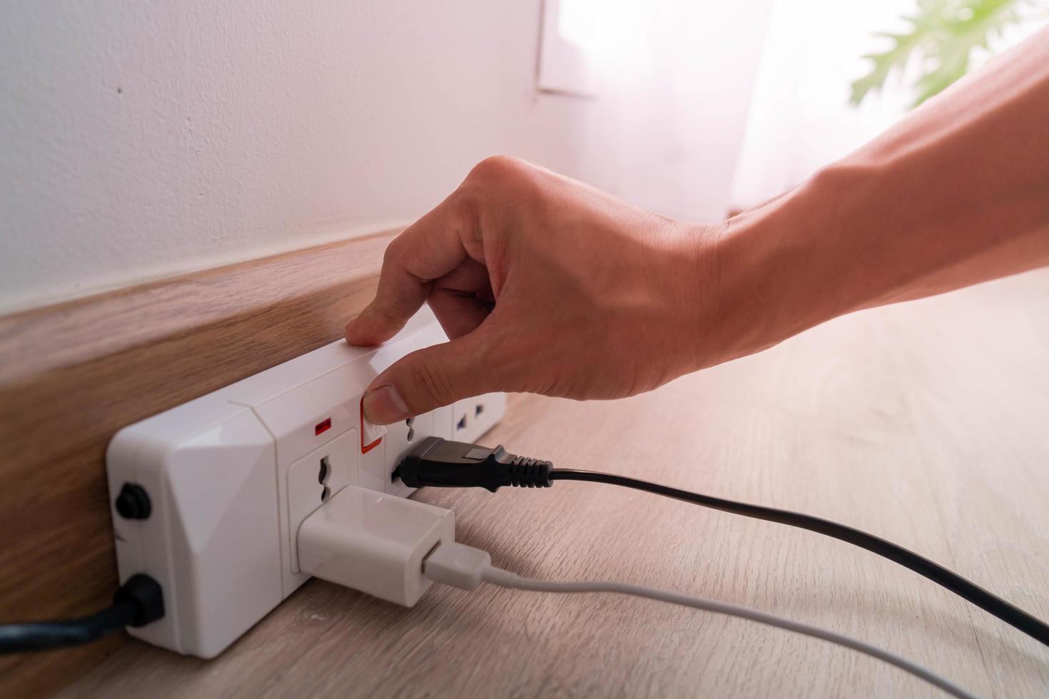 Ahorre electricidad, ahorro de energía y protección del medio ambiente. el dedo del hombre presiona el botón para apagar la luz. uso economico de la electricidad foto