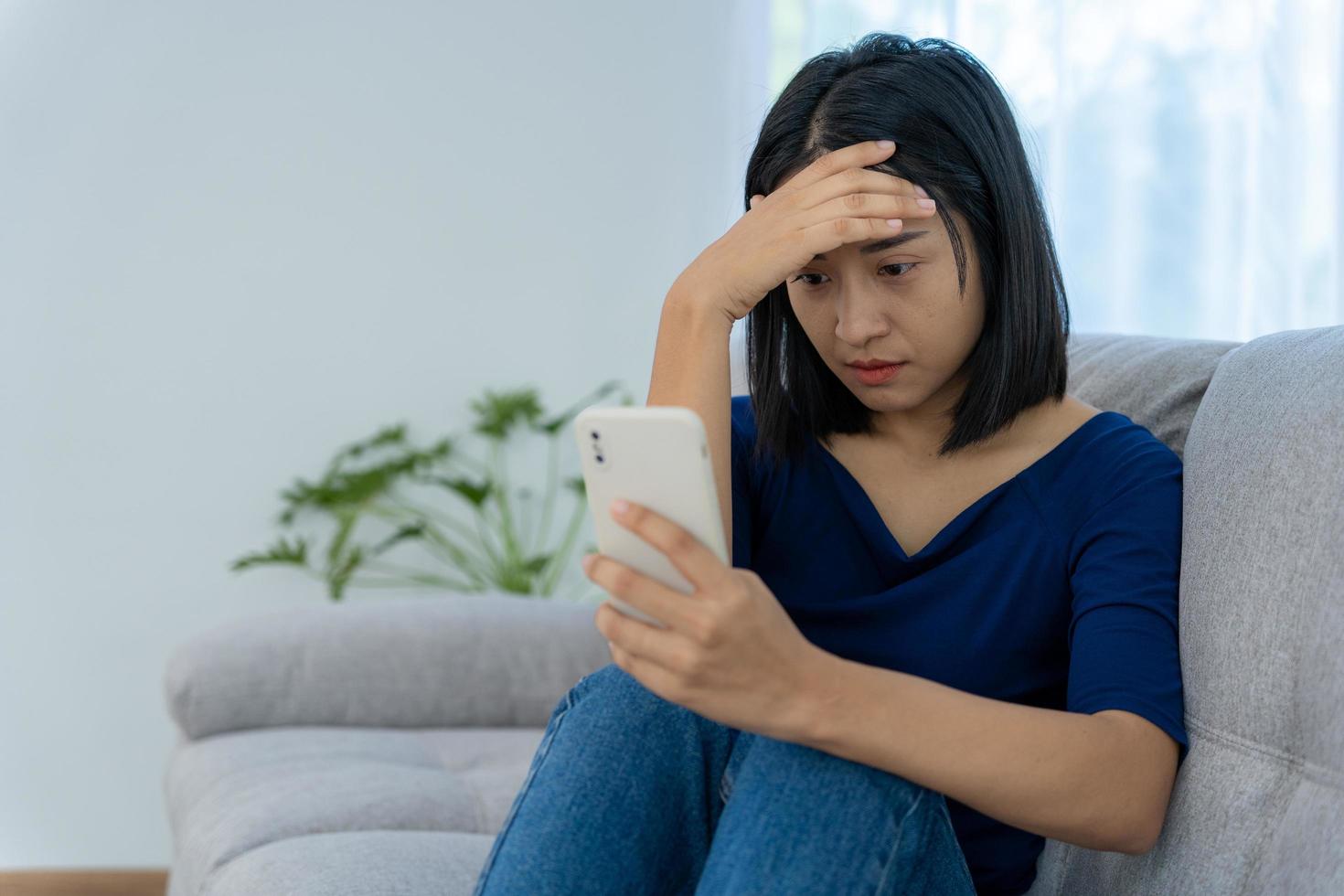 Beautiful Asian woman disappointed and sad after receiving bad news over the phone. Stressed girl confused with unhappy problems in life, arguing with her boyfriend. photo