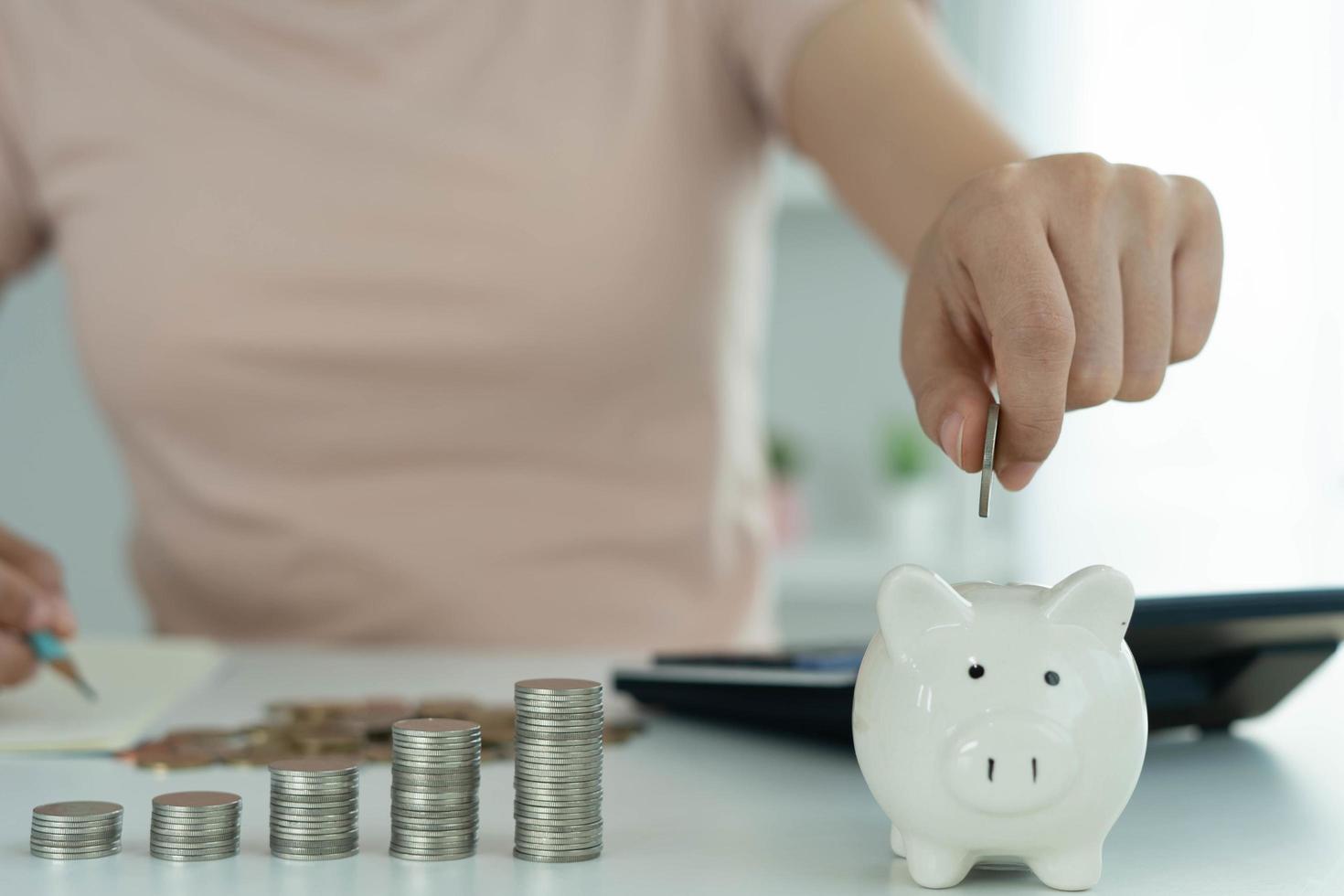 hucha con un montón de monedas. las mujeres deben tarjetas de crédito están calculando todos los gastos y pasivos. concepto de deuda foto