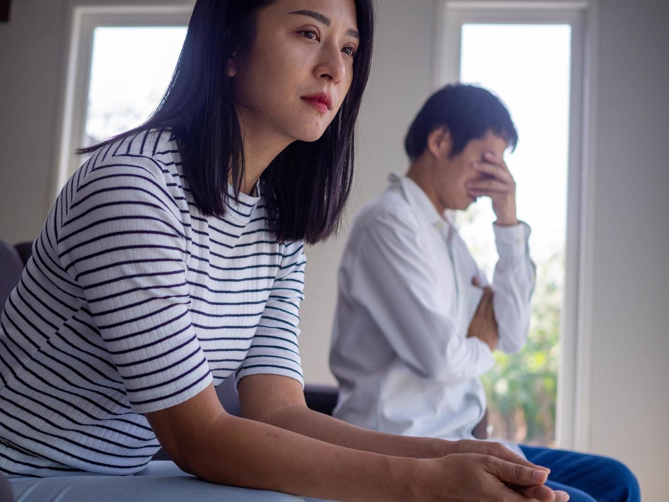 las mujeres asiáticas lloran y se irritan por el comportamiento de su marido. después de una discusión y causando dolor en el corazón. enojado y sin entenderse, resultando en divorcio foto