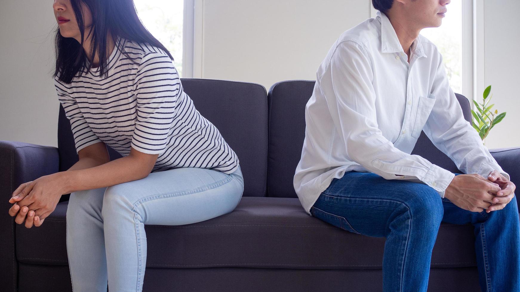 Love couple not talking after quarrel. Pensive upset woman feeling offended and thinking over problems in relationships. Upset man sitting in the background. divorce and love problem concept photo