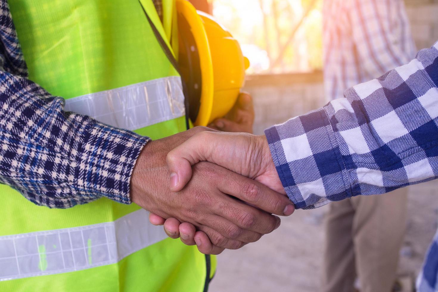 Construction worker team hands shaking greeting start up plan new project contract in office center at construction site, partnership and contractor concept photo
