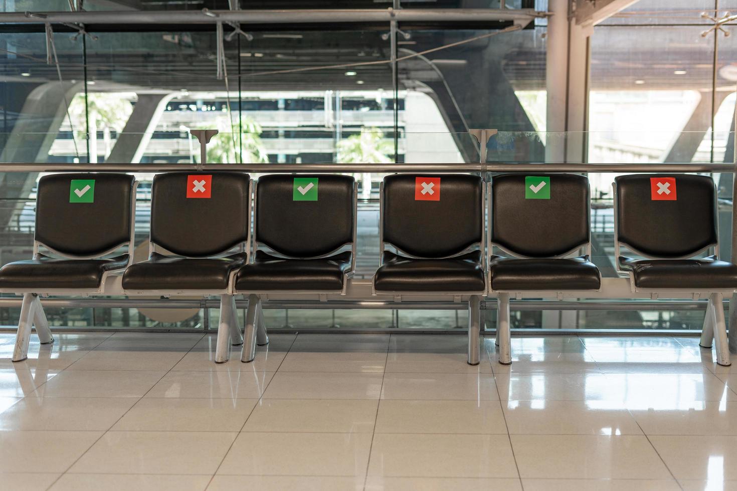 Public chair layouts spaced socially during the Covid-19 situation in the airport terminal. Social distance concept. photo
