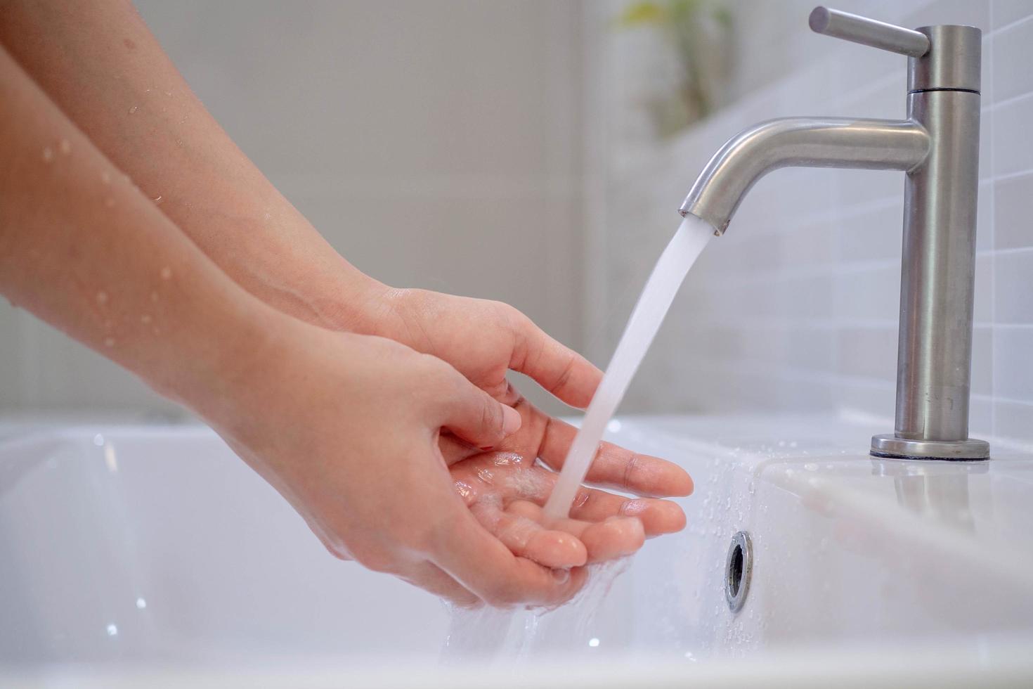 Wash your hands with soap, prevent virus and bacteria in the tap with running water. Good hygiene before eating or handling public items photo