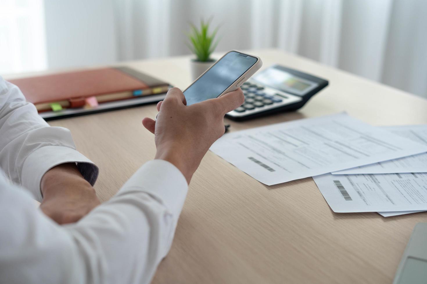 Businessman is using a mobile phone to scan the QR code for the bill through the app. Convenient, fast, is an option of modern. paying online from home. stay safe and have Social distance photo