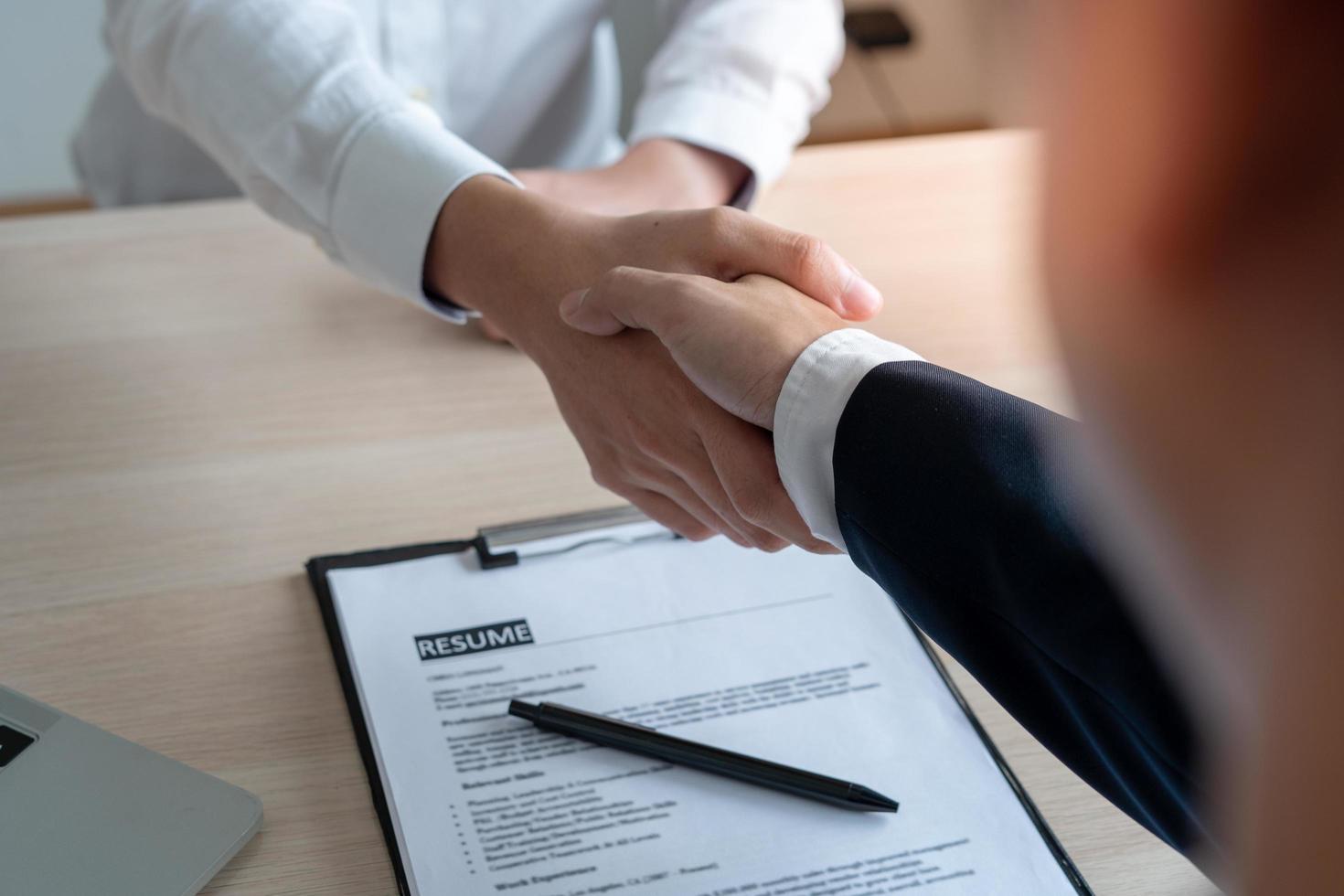 Businessmen and job seekers shake hands after agreeing to accept a job and approve it as an employee in the company. Or a joint venture agreement between the two businessmen photo
