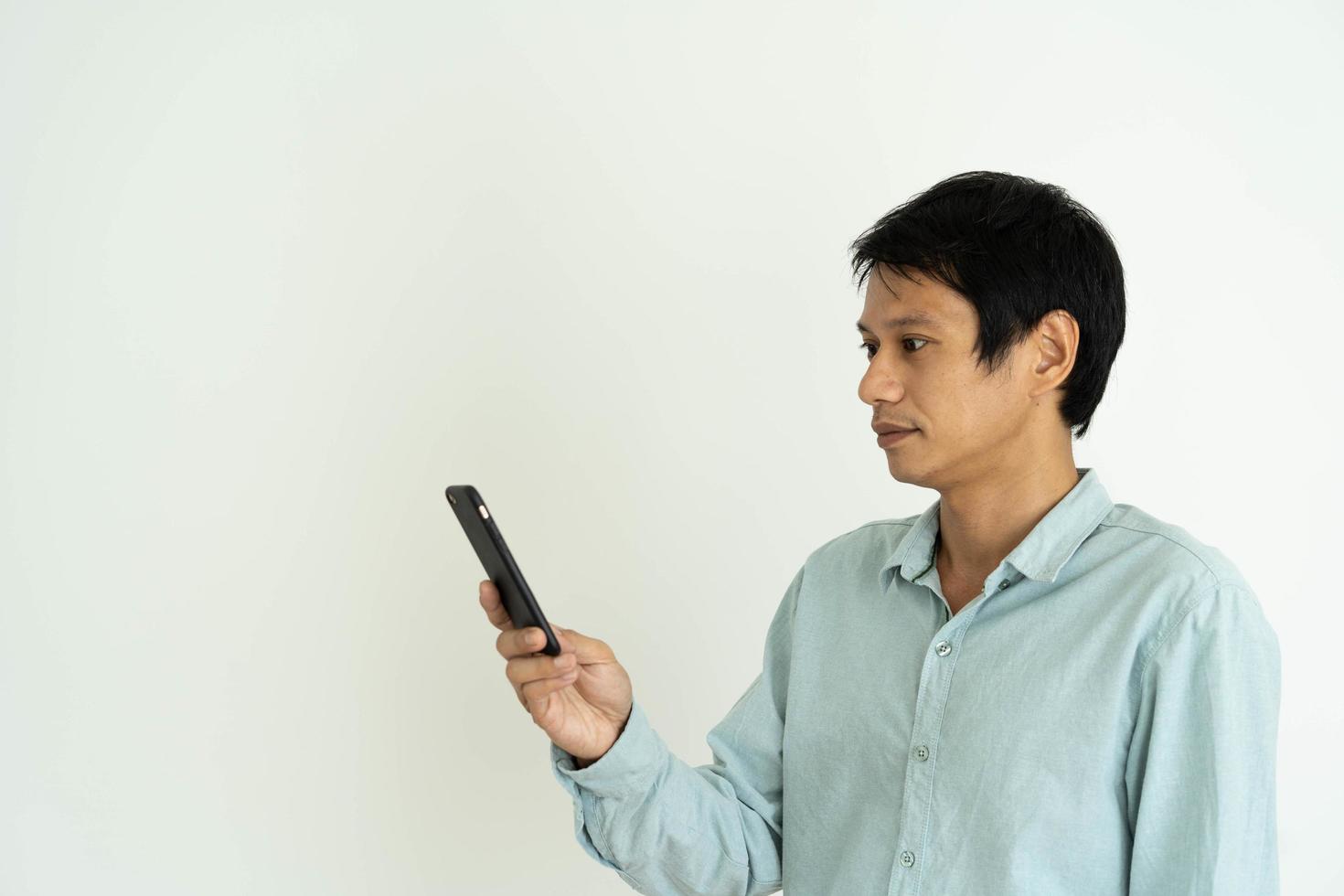 Asian man is shocked while looking at a mobile phone. Men do facial expressions, surprise messages or things that appear on their phones. photo