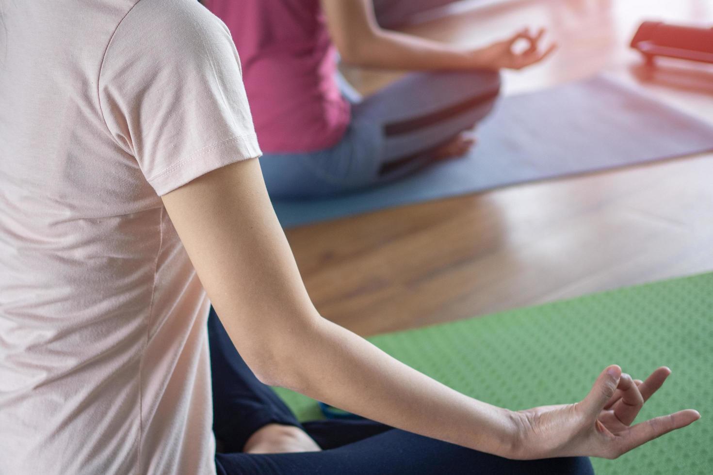 grupo de mujeres sentadas en la postura de meditación de yoga en la alfombra en el suelo relajada. conceptos de ejercicios de yoga foto