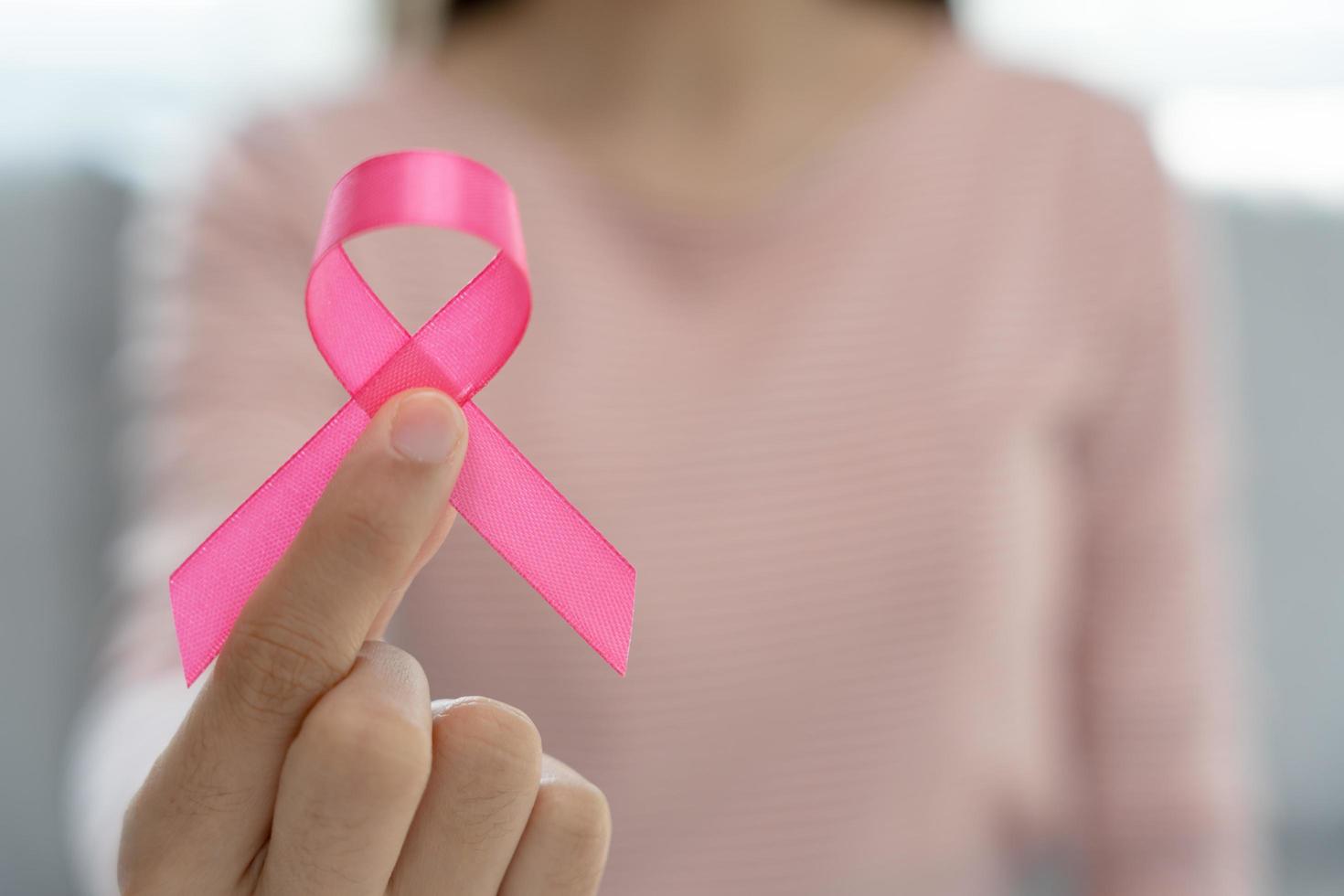 Woman hold pink ribbon breast cancer awareness. Female health check consciousness. international Women Day and World Cancer Day. sign cancer, Symbolic, health care, support patients, timely diagnosis photo