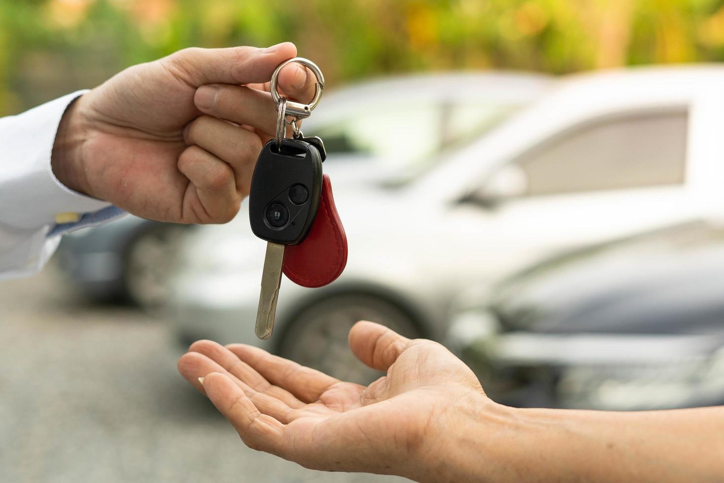 selling car, car sale, deal concept The dealer gives the car keys to the new owner or renter with an insurance contract. photo