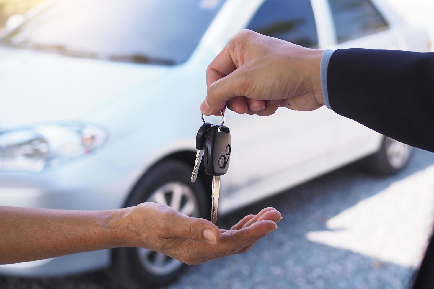 The car salesman and the key to the new owner. photo