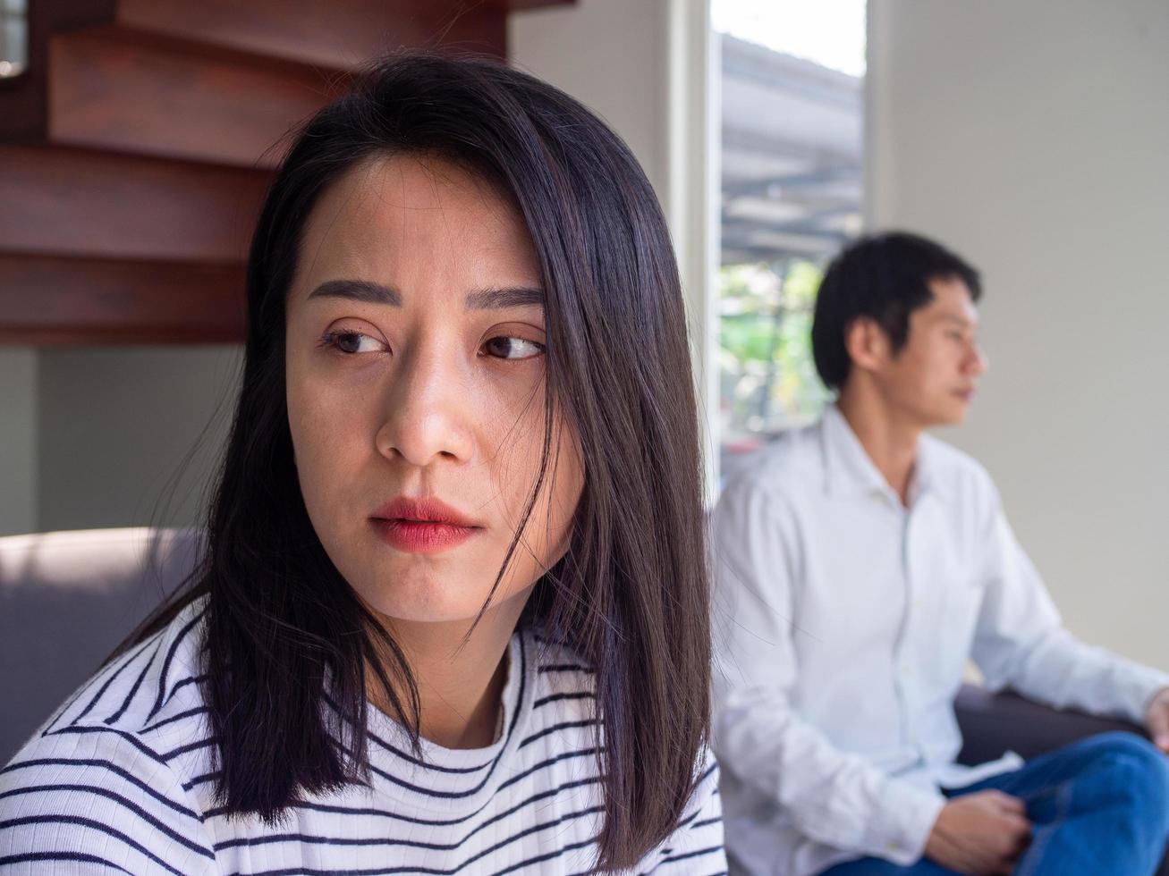 An Asian woman is unhappy and hurt after an argument with her husband due to their distrust. Concepts of family problems and love problems photo