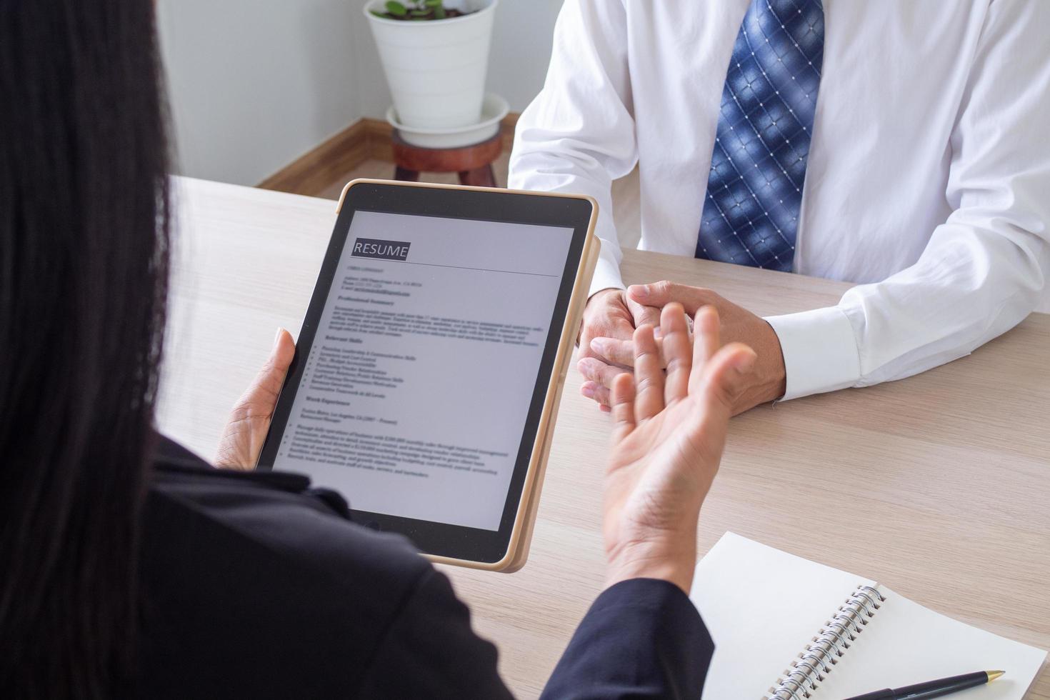 Businessmen open the resume for the applicant in an email via tablet during a job interview. Employment concept photo