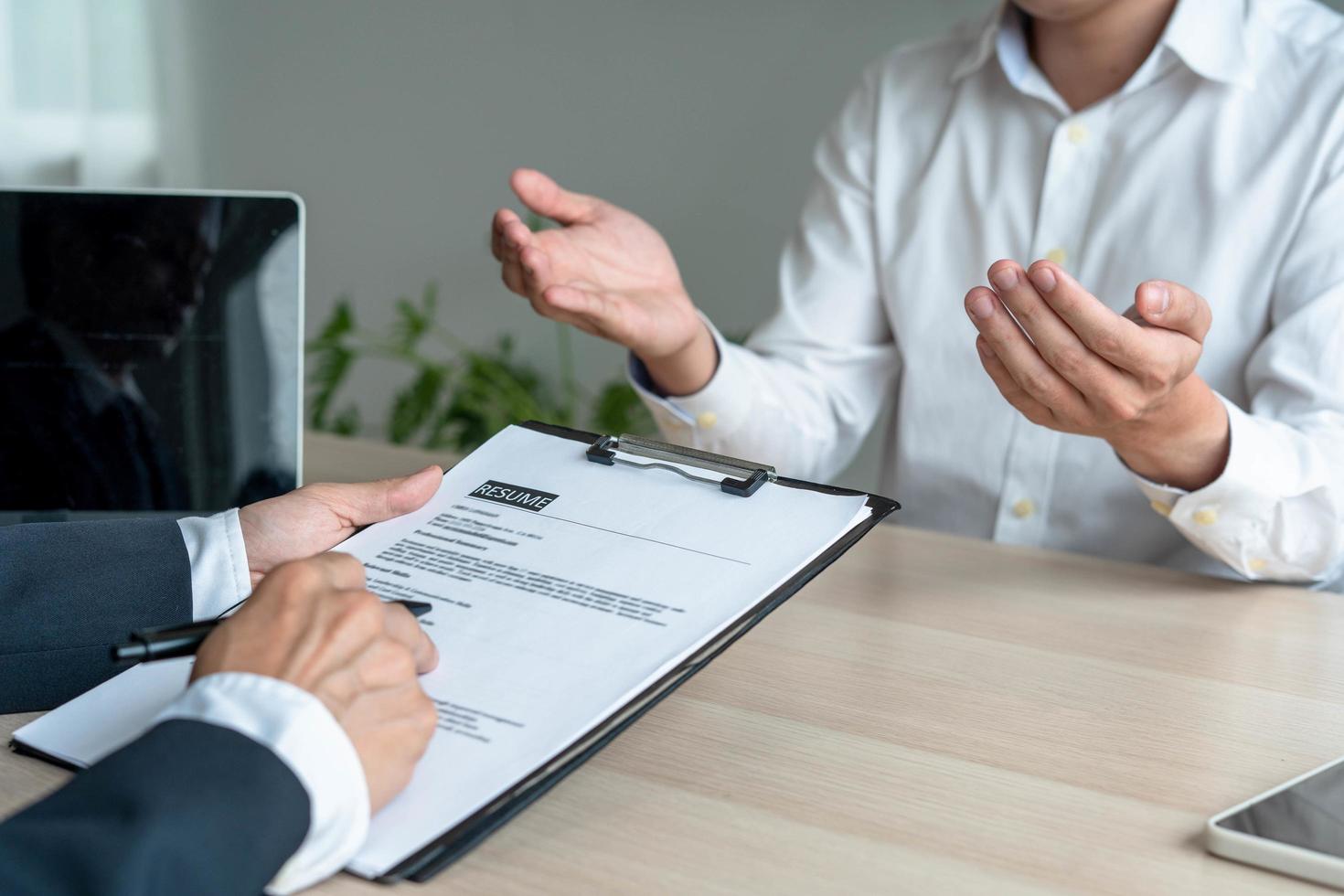 la mano de un hombre de negocios con un currículum. la gerencia está tomando la entrevista de trabajo del candidato del examen. concepto de currículum foto