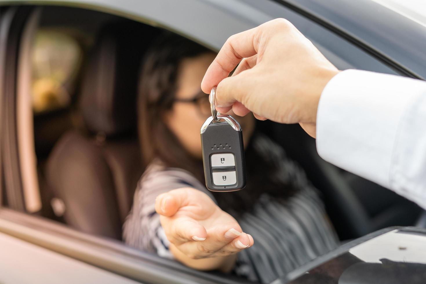 An employee of a tourist car rental company presents the car keys with a test drive. Good service before agreeing to a lease or purchase contract. photo