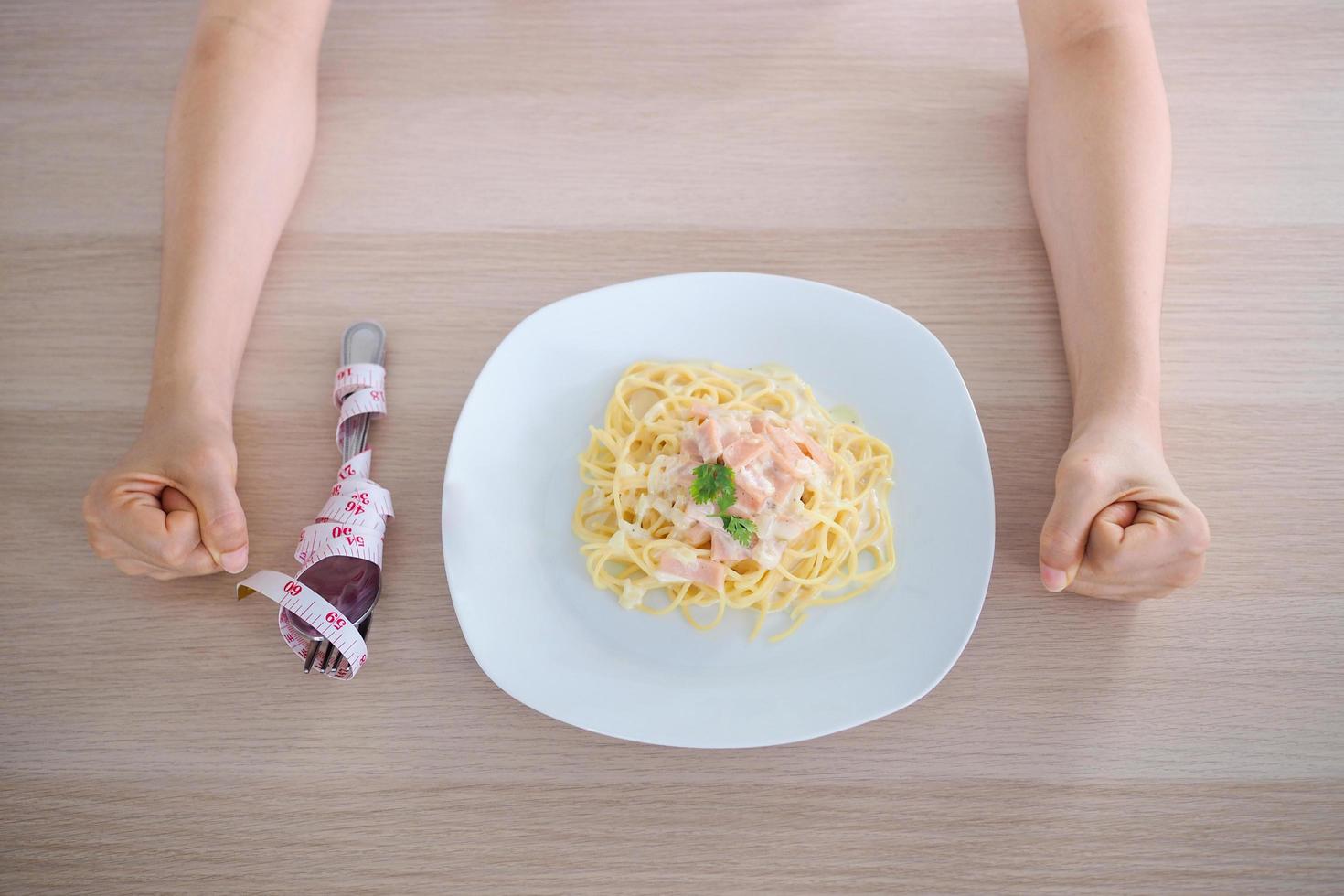 la niña tiene la intención de perder peso. reacios a comer la cabonara frente al concepto de elegir alimentos que sean buenos para la salud. foto